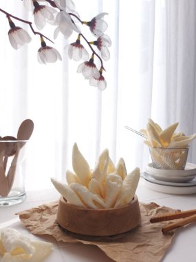 Kerupuk palembang. It is traditional chips from Palembang, south sumatera island, Indonesia. Fish flavor. Served on wooden bowl. Crunchy and savory taste. Bright mood photography concept