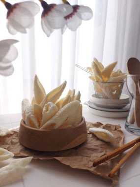 Kerupuk palembang. It is traditional chips from Palembang, south sumatera island, Indonesia. Fish flavor. Served on wooden bowl. Crunchy and savory taste. Bright mood photography concept