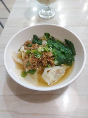 Yeşil sebzeli sos köftesi ve bir tutam yeşil soğan ve kızarmış soğan.