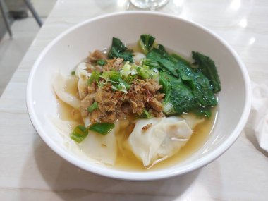 Yeşil sebzeli sos köftesi ve bir tutam yeşil soğan ve kızarmış soğan.