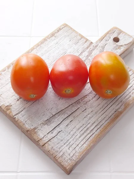 Trzy Pomidory Białym Stole Pojedyncze Tło — Zdjęcie stockowe