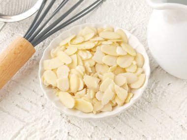 Beyaz tabakta dilimlenmiş badem. Genellikle pasta süsleme için kullanılır.