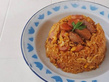Yumurtalı pilav, sosis ve köfte. Endonezya 'dan geleneksel kahvaltı menüsü. Emaye tabağında servis edilen tuzlu ve tatlı tat.