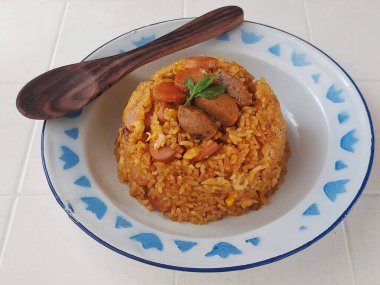 Yumurtalı pilav, sosis ve köfte. Endonezya 'dan geleneksel kahvaltı menüsü. Emaye tabağında servis edilen tuzlu ve tatlı tat.