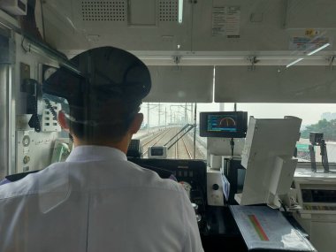 Jakarta, Endonezya-Ağustos 3-2023: makinistin odasının atmosferi banliyö hattında. Bir makinist, trenin hızını kullanarak görevdedir.