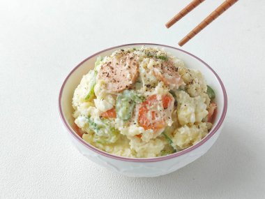 Japon patates salatası. Sirke, mayonez, haşlanmış yumurta, tuz, salatalık, havuç, sosis ve karabiberden yapılmış patates püresi. Kasede servis edilmiş. Geleneksel Japon yemekleri.. 