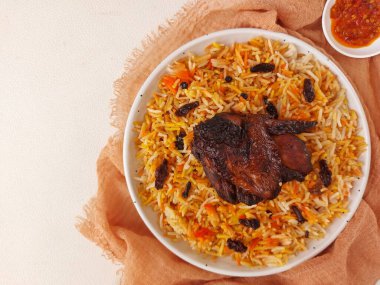 Nasi kebuli. Bu bir Endonezya pilav çeşididir. Pirinç pilavı, keçi eti çorbası, keçi sütü ve tereyağı içerir. Tavuk göğsüyle tamamlanmış. Beyaz tabakta servis edilmiş. Tadı tuzlu