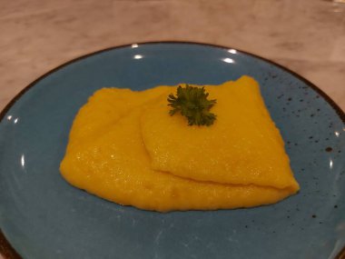 Mavi tabakta patates püresi. Taze kerevizle süslenmiş.