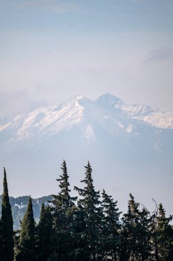 Bulutların arkaplanındaki dağ zirvesi