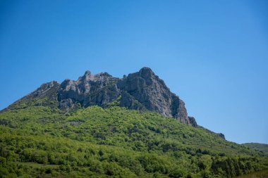 Arka planda mavi gökyüzü olan kayalık dağların yüksek kaliteli bir görüntüsü.