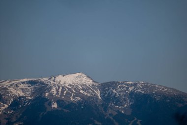 Güneş ve bulutlarla dolu dağ zirvesi