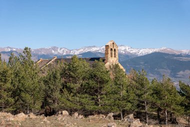 Mavi gökyüzünün altındaki tepede terk edilmiş bir kilisenin dikey görüntüsü.