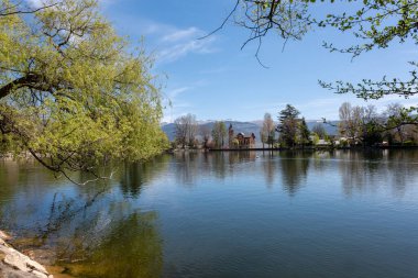 Arkasında ağaçlar ve dağlar olan bir göl.