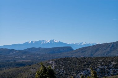 Mavi gökyüzü ve beyaz bulutlarla dağların güzel manzarası.