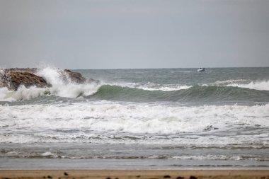 Okyanus kıyısında dalgalar kopuyor.