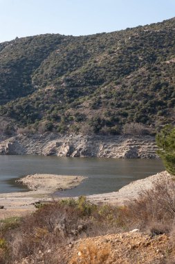 Denizin dikey görüntüsü ve güneş ışığı altında dağlarda küçük bir tekne.