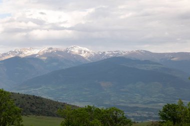 Dağları ve mavi gökyüzü olan güzel bir manzara.