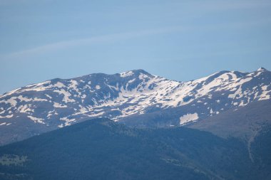 Mavi gökyüzüyle dağ zirvesi. Arkaplanda dağ zirveleri, kar - zirveler, bulutlar, mavi gökyüzü, bulutlar ve güneş