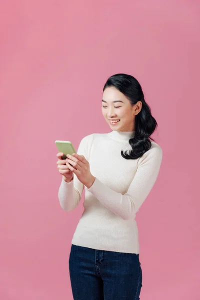 Χαρούμενο Κορίτσι Χαμογελά Ενώ Συνομιλεί Smartphone Απομονωμένο Ροζ — Φωτογραφία Αρχείου