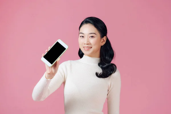 Красивая Азиатка Держит Пустой Экран Смартфона Розовом Фоне — стоковое фото