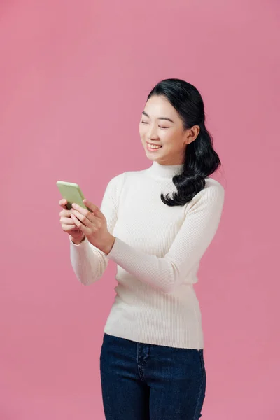 Usmívající Krásná Mladá Žena Stojící Pomocí Mobilního Telefonu Přes Růžové — Stock fotografie