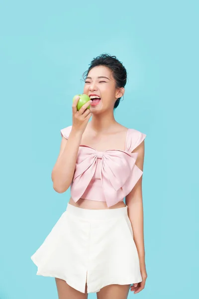 Portret Wesołej Młodej Kobiety Jedzącej Zielone Jabłko Niebieskim Tle — Zdjęcie stockowe