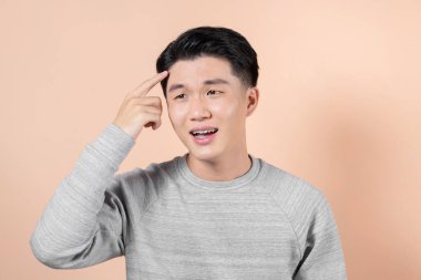 Genç Asyalı adam alnındaki sivilceden mutsuz olduğunu söylüyor.,