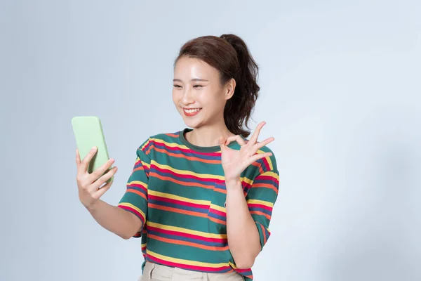 漂亮的年轻女人带着智能手机示好的标志 — 图库照片