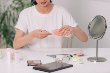 Güzellik rutini. Çekici genç bir kadın aynanın yanında dikilirken pamuk pede süt sürüyor.