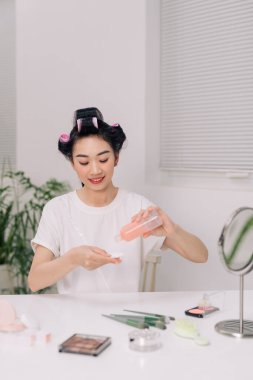 Yüzüne yüz temizleme bezi süren genç bir kadın. Makyaj, esans ya da cilt bakımı losyonu.