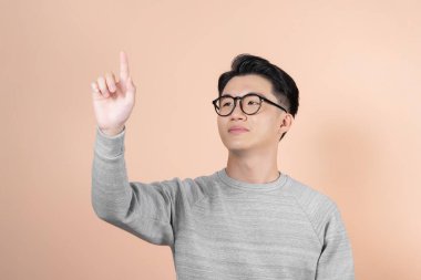 Akıllı görünümlü bir adam kafasını kaldırıp, sanki büyük bir dokunmatik ekranı manipüle eder gibi elini tutar.