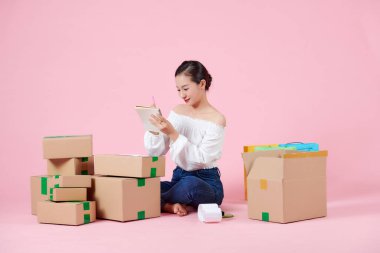 Young beautiful asian woman prepare to send products by orders to her costomers