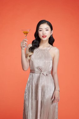 Parlak elbiseli, elinde bir kadeh şampanya tutan ve kutlama yapan zarif bir kadın.