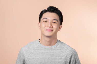 Asian man smiling on beige