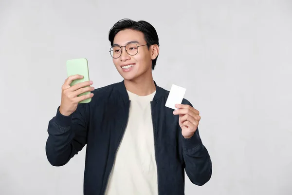 Young Asian Man Holds Credit Card Smartphone Isolated White Background — Foto de Stock