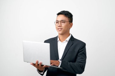 Young asian businessman standing work on laptop computer to internet online