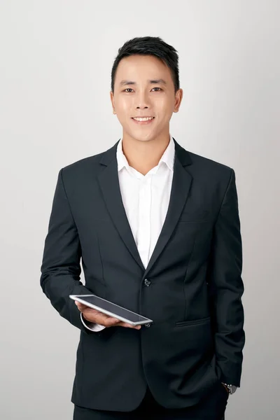 白い背景に隔離されたインターネットにタブレットコンピュータを使用して立ってスーツ姿の若いアジアのビジネスマンの肖像画 — ストック写真