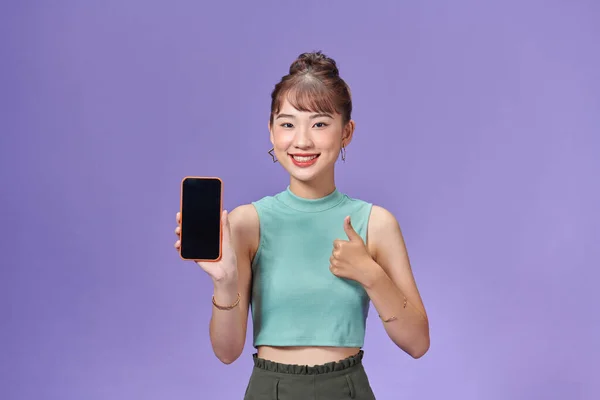 stock image Satisfied happy asian girl show thumbs up as demonstrate mobile phone screen application