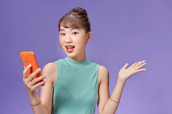 年轻的亚洲女人兴奋地拿着电话 — 图库照片