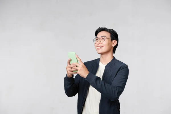 stock image Portrait of cheerful man using cellphone and smiling, reading good news message, enjoying mobile application