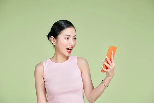 Портрет Удивленной Молодой Азиатки Использующей Мобильный Телефон Зеленом Фоне — стоковое фото