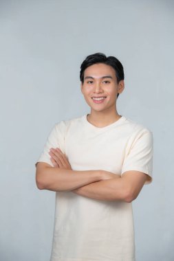 çapraz kol ve memnuniyeti ile kameraya bakarak gündelik genç adam