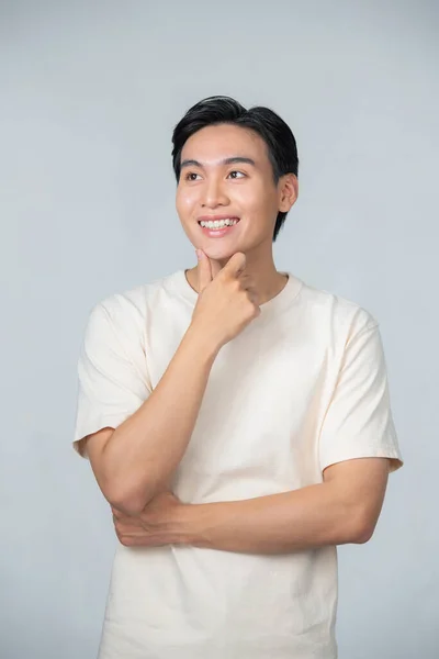 Yakışıklı Asyalı Adam Gri Arka Planda Çenesine Dokunarak Poz Veriyor — Stok fotoğraf