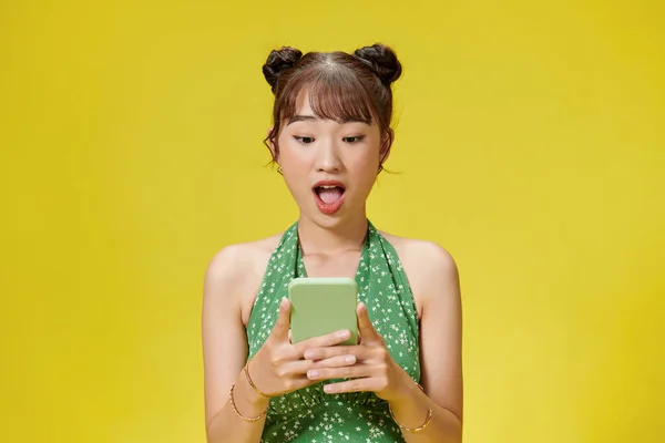 Шокована Збуджена Молода Жінка Позує Телефоном Ізольовано Жовтому Фоні — стокове фото