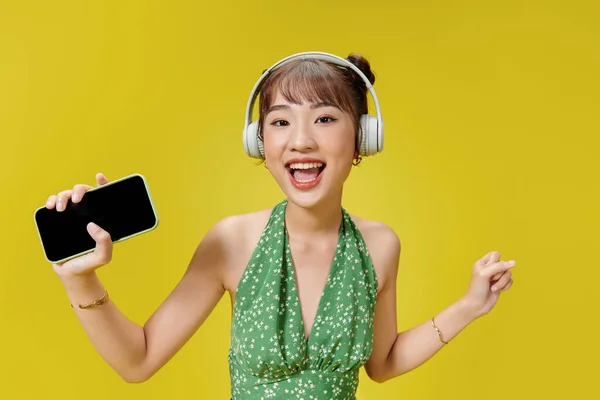Szczęśliwa Młoda Kobieta Słuchawkach Słuchających Muzyki Jaskrawym Żółtym Tle — Zdjęcie stockowe