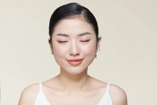 茶色の背景にきれいな新鮮な肌を持つ美しい若いアジアの女性 — ストック写真