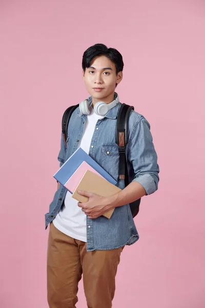 Pozitivní Mladý Muž Batohem Sluchátka Notebooky Pózovat Růžovém Pozadí — Stock fotografie