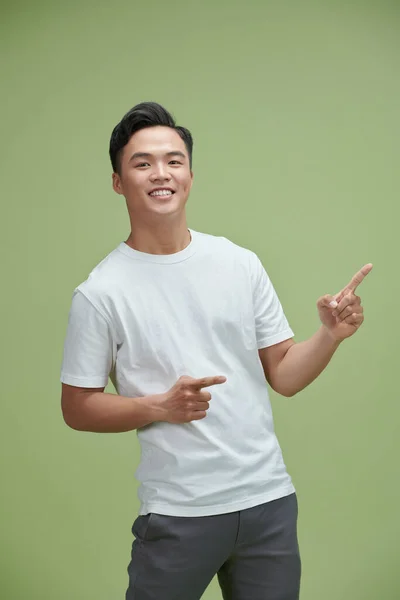 Snygg Ung Asiatisk Man Ler Med Fingrarna Pekar Isolerad Ljusgrön — Stockfoto
