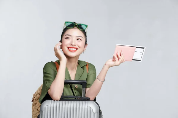 Ενθουσιασμένη Ασιάτισσα Δείχνει Διαβατήριο Εισιτήρια Χαμογελαστή Ικανοποίηση Στέκεται Βαλίτσα Γκρι — Φωτογραφία Αρχείου