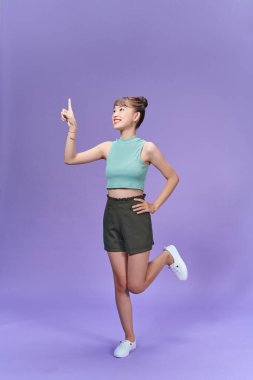 Mor arkaplanda yalnız poz veren güzel bir bayanın fotoğrafı